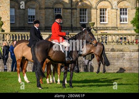 Aske Hall, Richmond, North Yorkshire, UK - February 08, 2020: Horse riding hunt official wearing traditional red coat in front of a traditional Georgi Stock Photo