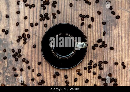 Cup of coffee and beans on wooden table Stock Photo