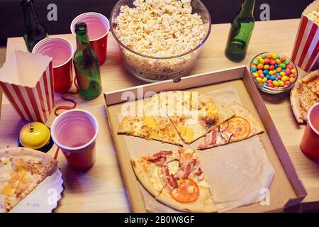 Close-up of pizza popcorn and alcohol drinks on the table at the party Stock Photo