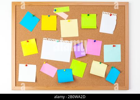 Cork board with several colorful blank notes with pins Stock Photo