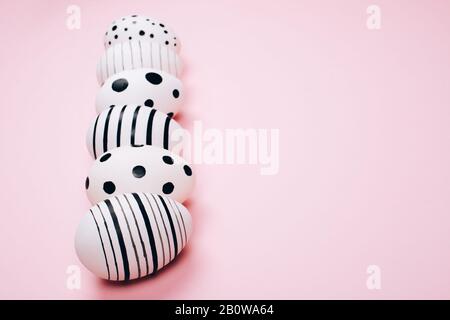 Many easter eggs on trendy pink pastel background. Eggs are hand-drawn. Flat lay style. Stock Photo
