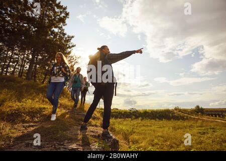 Young people with backpacks walking in the forest Stock Photo