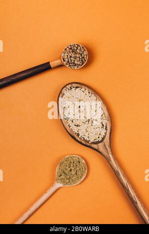 Different types of uses for hemp. Seeds, protein and powder in wooden spoons. Stock Photo