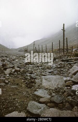 Abandoned ruins of the Mramorny camp of the Gulag forced-labour camp system in the Kodar Mountains in the Transbaikal Region in Siberia, Russia. The camp was established in January 1949 in the altitude about 2,150 metres (7,000 ft) above sea level to serve the nearby Uranium mine. The politician prisoners of Soviet regime used to work here in the extremely hard conditions forced to live in large canvas tents even in winter. The camp was closed in October 1951 because Uranium reserves were depleted here. The photograph was taken in August 1994. Stock Photo