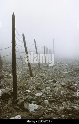 Abandoned ruins of the Mramorny camp of the Gulag forced-labour camp system in the Kodar Mountains in the Transbaikal Region in Siberia, Russia. The camp was established in January 1949 in the altitude about 2,150 metres (7,000 ft) above sea level to serve the nearby Uranium mine. The politician prisoners of Soviet regime used to work here in the extremely hard conditions forced to live in large canvas tents even in winter. The camp was closed in October 1951 because Uranium reserves were depleted here. The photograph was taken in August 1994. Stock Photo