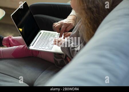 Happy loving family. Grandmother and grandchild spending time together. Watching cinema, using laptop, laughting. Mother's day, celebration, weekend, holiday and childhood concept. Close up of hands. Stock Photo