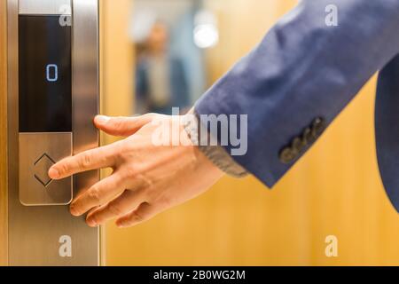 Man forefinger pressing up or down elevator button. Business success or failure concept. Stock Photo