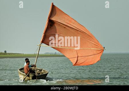 Small boat with as orange sail on the Kaladan River in Sittwe, Myanmar Stock Photo