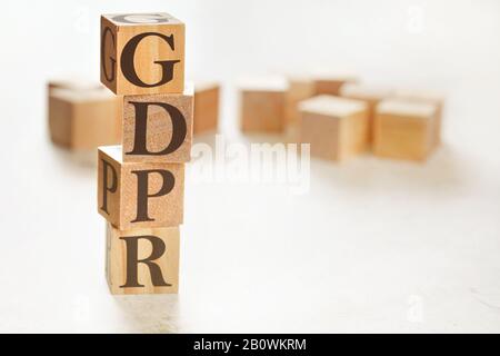 Four wooden cubes arranged in stack with letters GDPR meaning General Data Protection Regulation on them, space for text image at down right corner Stock Photo