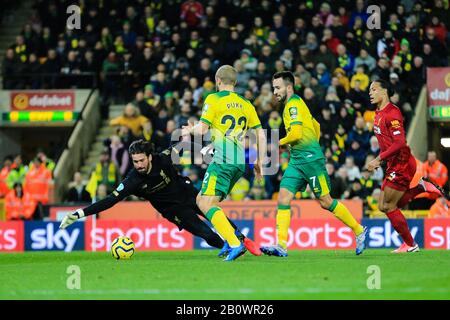 15th February 2020, Carrow Road, Norwich, England; Premier League, Norwich City v Liverpool : Alisson (1) of Liverpool is forced into action by Teemu Pukki (22) of Norwich City and Lukas Rupp (07) of Norwich City Stock Photo