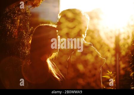 Young couple in love kissing against the light Stock Photo