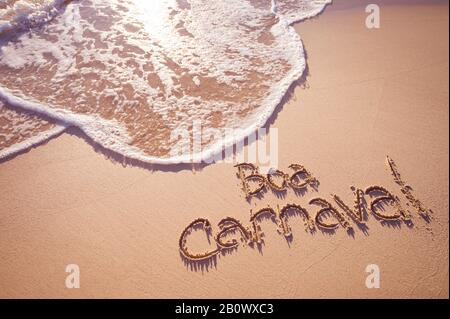 Boa Carnaval message in Portuguese (TRANSLATION: Happy Carnival) handwritten on smooth sand beach Stock Photo
