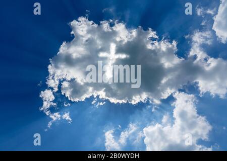 heaven concept light cross coming through the clouds on sunny sky Stock Photo