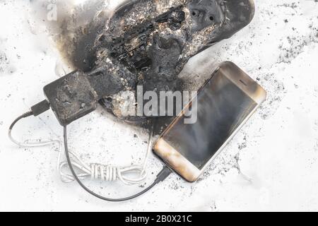 the burned-down power supply, phone, view on the top possible cause of the fire Stock Photo