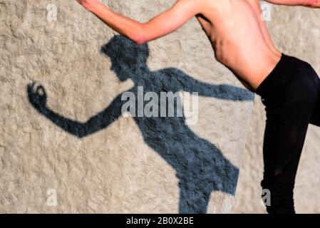 Shadow of the silhouette of a young man posing like a dance. Stock Photo