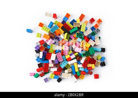 Close-up of a cluttered pile of colorful Lego bricks viewed from above, isolated on white background. Top view. Stock Photo
