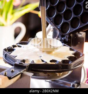 Put the waffle dough into a waffle iron Stock Photo