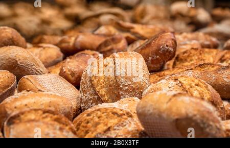 Sourdough bread buns close-up. Many bread rolls. Freshly baked bread. Organic whole-wheat loaves. Mini bread pile. Bakery bread buns merchandise. Stock Photo