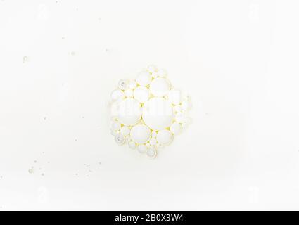 Milk bubbles in an oily layer. Milk surface with particles. Cosmetic background. Cooking ingredient. Milk and oil mixture surface. Stock Photo