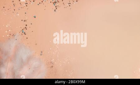 blurred Easter yellow festive background with beautiful feathers, glitters spring concept, copy space, top view Stock Photo