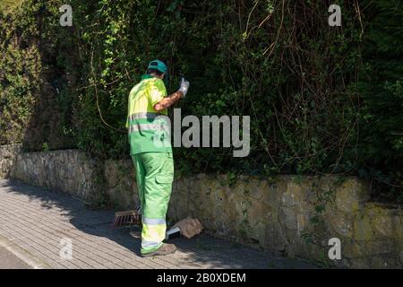 Street sweeper with broom working on a sidewalk. Public cleaning concept Stock Photo