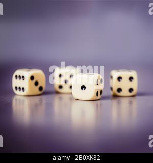 Four dices on a gray violet background, copy space Stock Photo