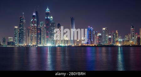 Reflections of Tallest Block on the Planet and Marina skyscrapers (Ocean Heights, Princess Tower, Marriott, The Torch, Elite Residences, Grosvenor House, Al Habtoor Grand) at night, New Dubai, United Arab Emirates, Stock Photo