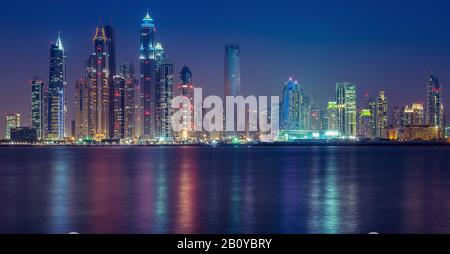 Reflections of Tallest Block on the Planet and Marina skyscrapers (Ocean Heights, Princess Tower, Marriott, The Torch, Elite Residences, Grosvenor House, Al Habtoor Grand) at night, New Dubai, United Arab Emirates, Stock Photo