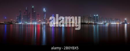 Reflections of Tallest Block on the Planet and Marina skyscrapers (Ocean Heights, Princess Tower, Marriott, The Torch, Elite Residences, Grosvenor House, Al Habtoor Grand) at night, New Dubai, United Arab Emirates, Stock Photo