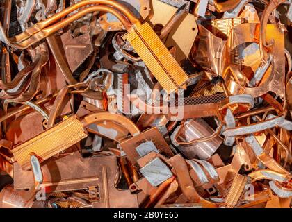 A pile of scrap copper for recycling. The copper is mostly heat pipe and heat exchangers from laptop cooling systems. Some thermal paste visible. Stock Photo