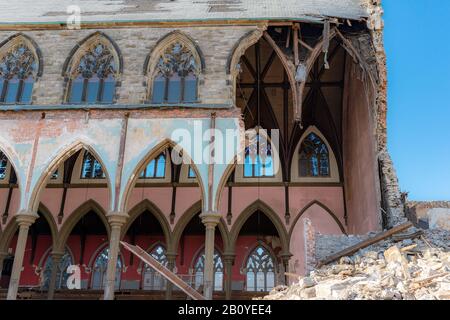 Ruins of a gothic church being demolished. Much of the wall facing the viewer is missing, interior wall on the other side is visible.A bit of blue shy Stock Photo