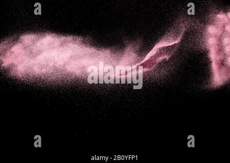 Pink dust particles splash on black background. Stock Photo