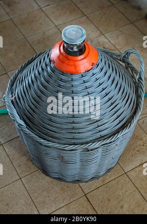 Large wine bottle with a basket. Stock Photo
