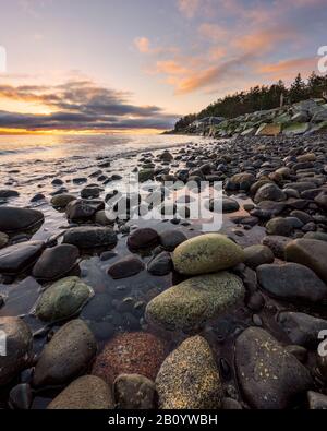 Beautiful colored rocks in front of sunrise along remote beach on Vancouver Island, British Columbia, Canada Stock Photo