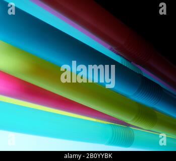 Background from multi-colored plastic cocktail tubes on a dark background Stock Photo
