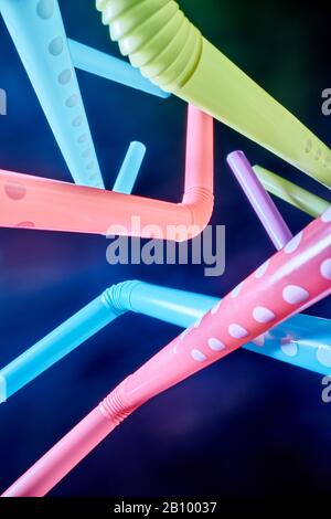 Background from multi-colored plastic cocktail tubes on a dark background Stock Photo
