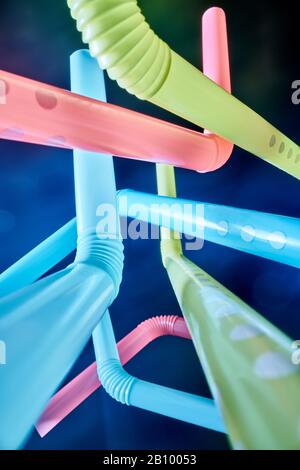 Background from multi-colored plastic cocktail tubes on a dark background Stock Photo