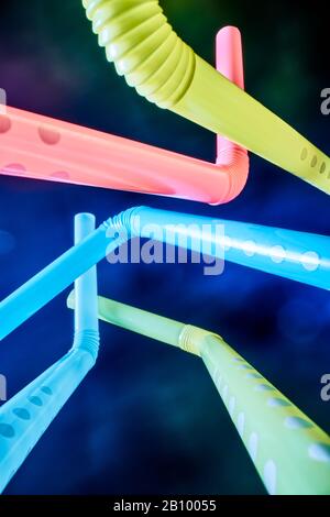 Background from multi-colored plastic cocktail tubes on a dark background Stock Photo
