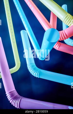 Background from multi-colored plastic cocktail tubes on a dark background Stock Photo