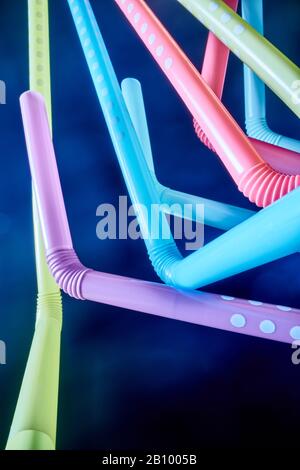 Background from multi-colored plastic cocktail tubes on a dark background Stock Photo