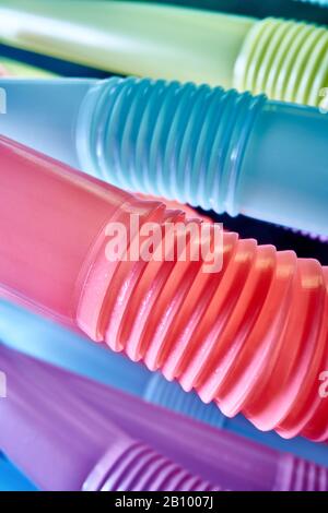 Background from multi-colored plastic cocktail tubes on a dark background Stock Photo