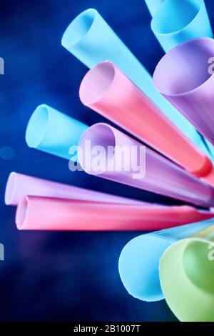 Background from multi-colored plastic cocktail tubes on a dark background Stock Photo