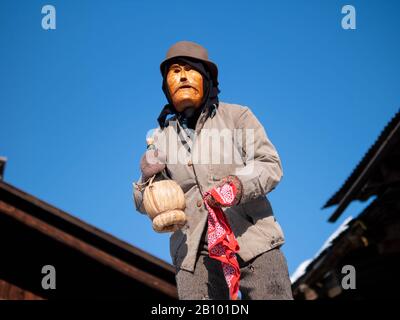 A man wearing a mask takes part during the carnival.Traditional carnival in Sappada, a German speaking town in Dolomiti Mountains in Italy, where people still use their special old-fashioned German dialect, is divided into three Sundays: Sunday of the poor, Sunday of peasants and Sunday of lords. People wear traditional wooden masks named Love and play funny characters to entertain neighbours and visitors. The most important mask is Rollat, huge man in sheep skin coat with wooden face of shepherd. Stock Photo