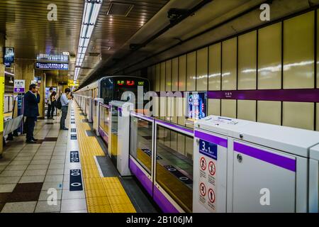 Passengers waiting for their train at subway underground station. Travelling by Tokyo metro. Stock Photo