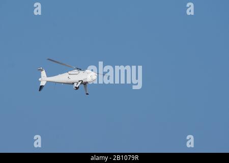 Military drone unmanned aircraft flies through the blue sky on a mission of surveillance. Military war, technology, and middle east concepts. Stock Photo