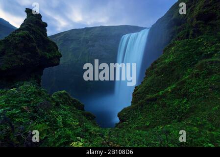 Skogafoss with stone faces after sunset, Iceland Stock Photo