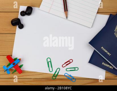 Travel concept.Top view accessories travel with passports, notepad, paper, pencil, earphones, toy airplane, clips on table wooden with copy space. Stock Photo