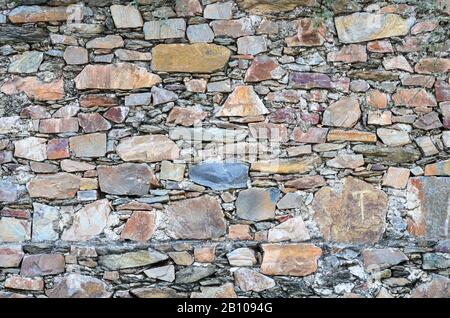 Typical boundary walls made of colourful stones typically found in the villages in Rajasthan, India Stock Photo