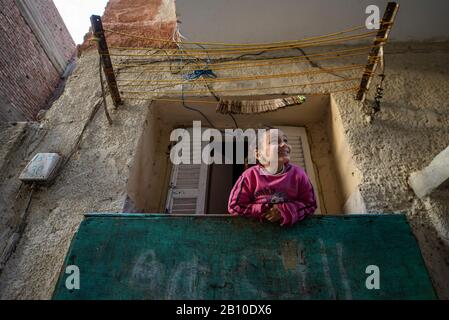 Little girl looks out the window in Cairo's old quarter, Egypt Stock Photo