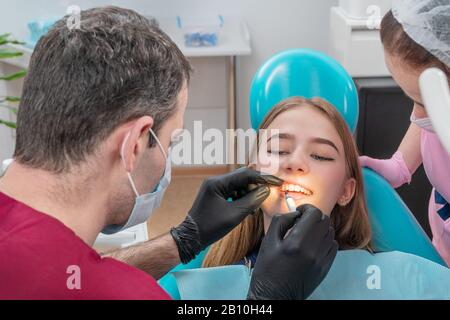 doctor puts the medicine on tooth Stock Photo